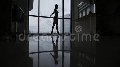 窗户边一个芭蕾舞演员的剪影。 窗前一位<strong>年轻</strong>的女芭蕾舞演员倒映在镜子地板上。 这<strong>就是</strong>